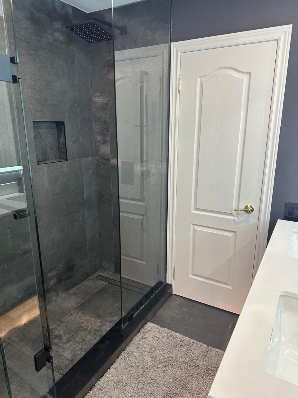 Concrete-look shower stall with glass door and double vanity