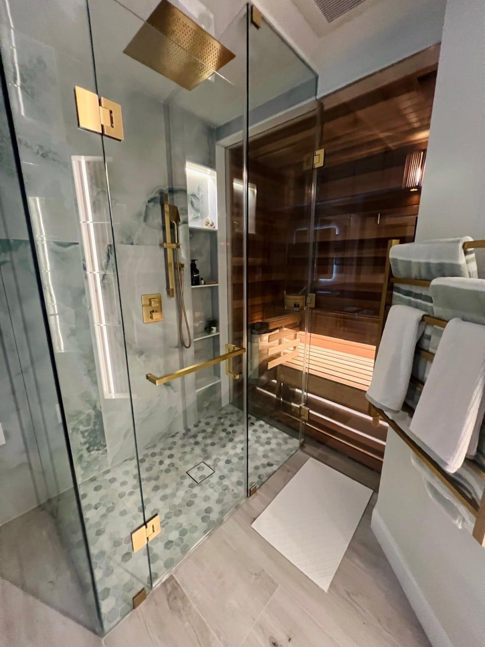 Onyx steam shower beside a cedar sauna with gold hardware