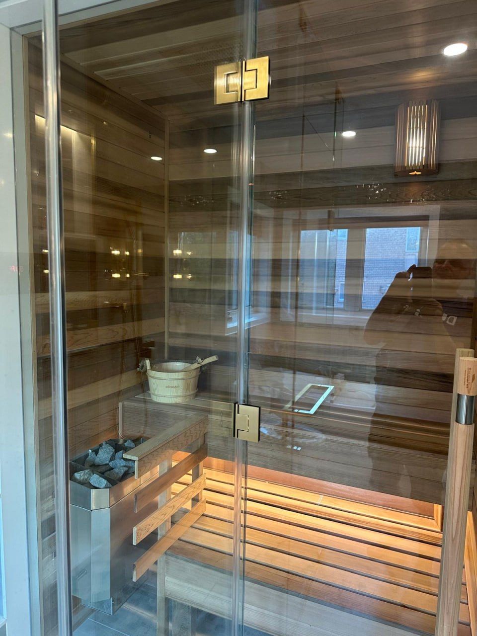 Cedar sauna interior with heater and bucket