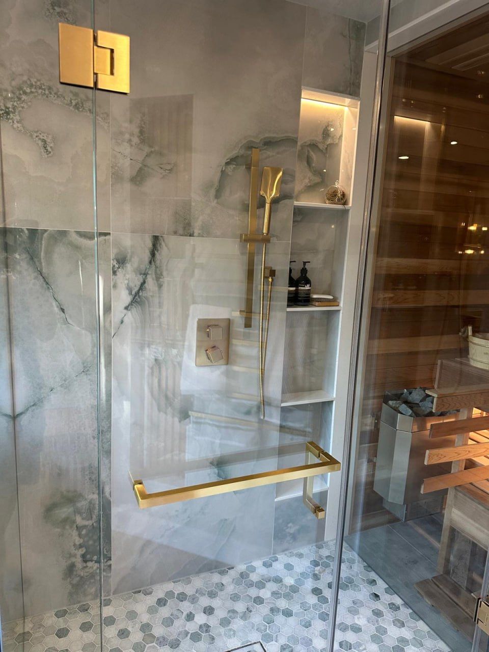 Onyx steam shower with brushed gold fixtures and open shelving
