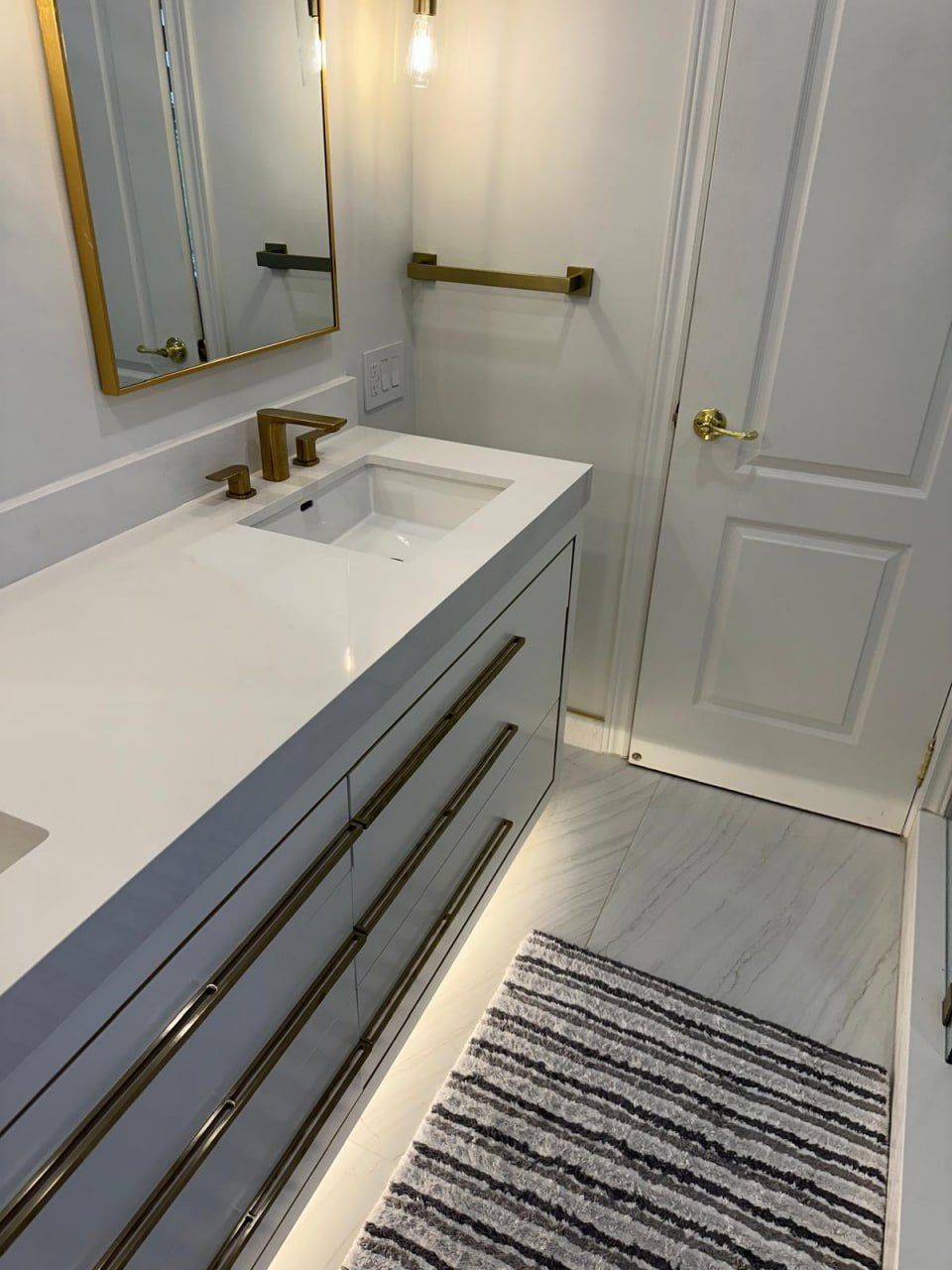 Grey double vanity with brushed gold faucets