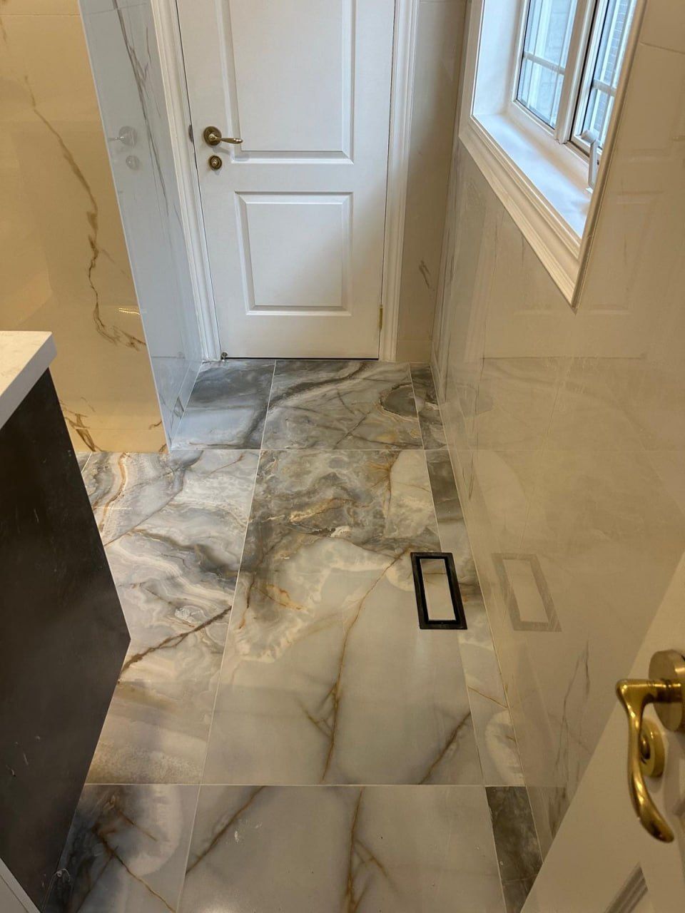 Onyx-look porcelain bathroom floor with linear drain