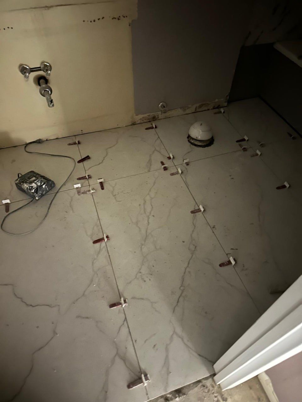 Floor tiles set with levelling clips and wedges