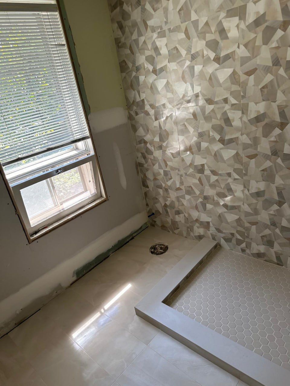 Geometric feature tile and shower curb under construction