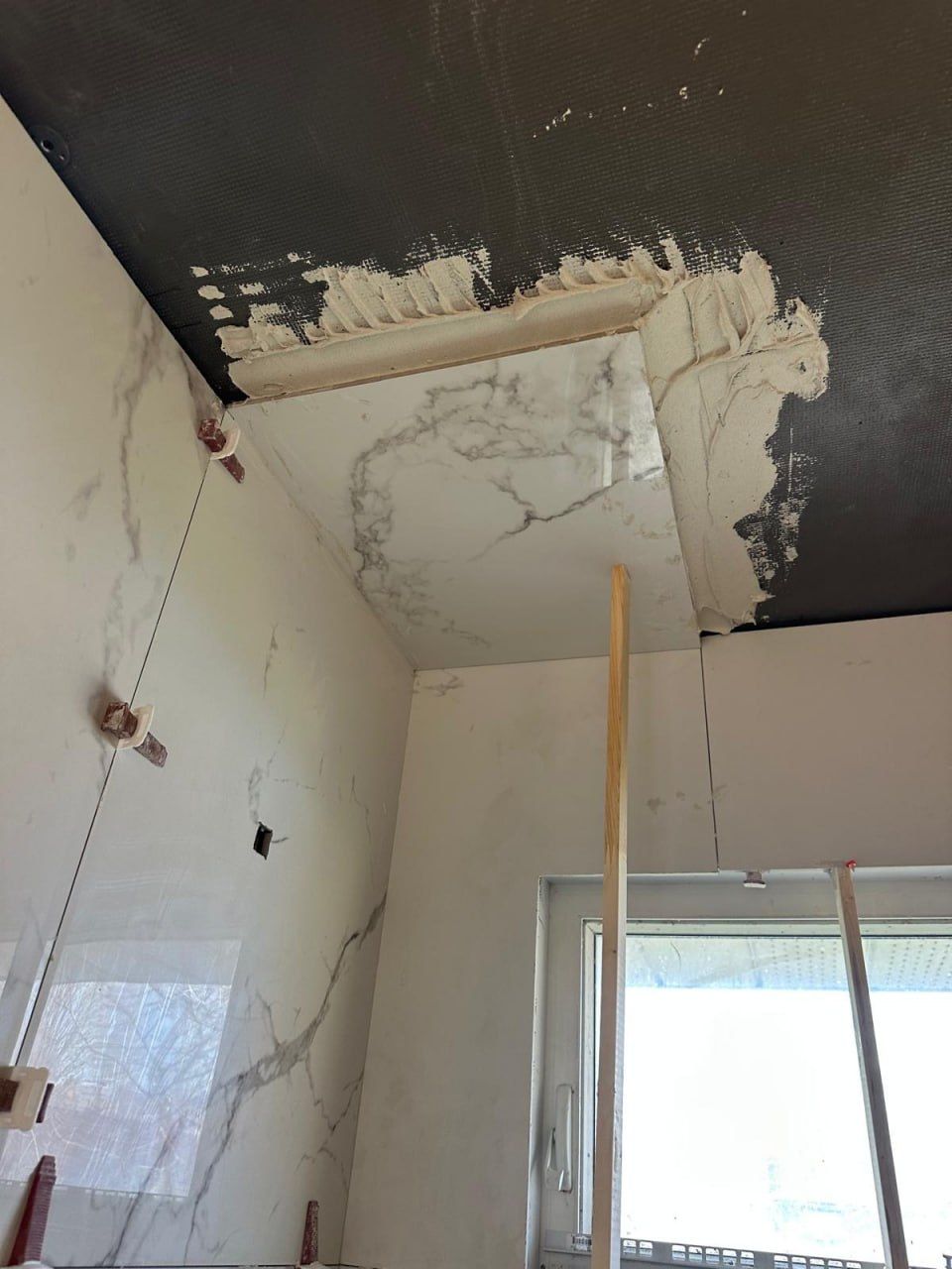 Waterproof backer board on ceiling before marble tiling