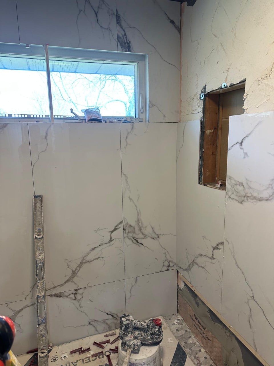 Marble wall tiling checked with a spirit level