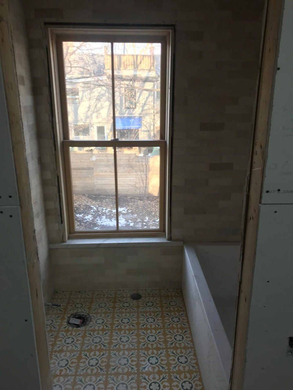 Cream tile walls with patterned floor and window reveal