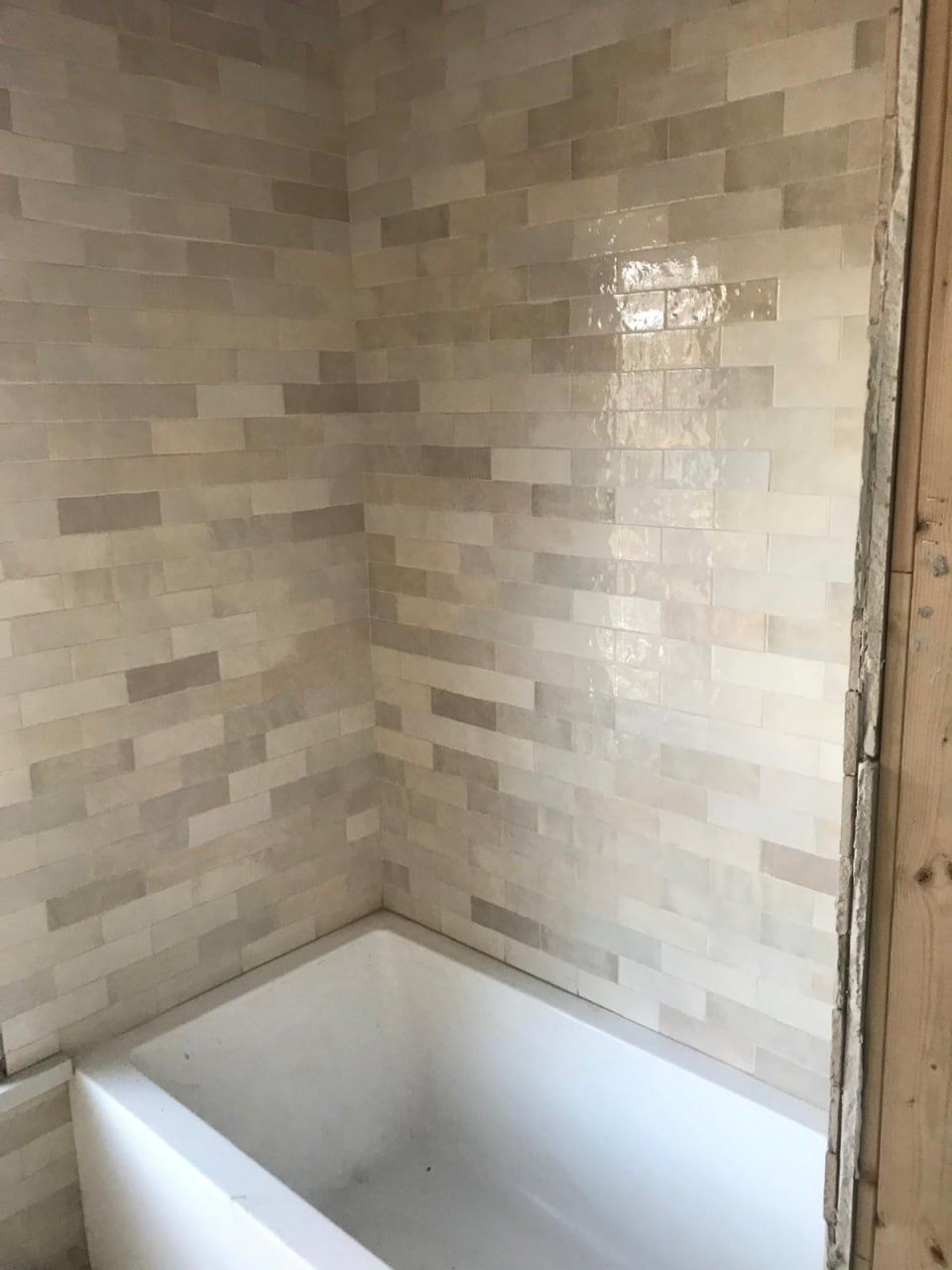 Cream zellige tub surround mid-installation