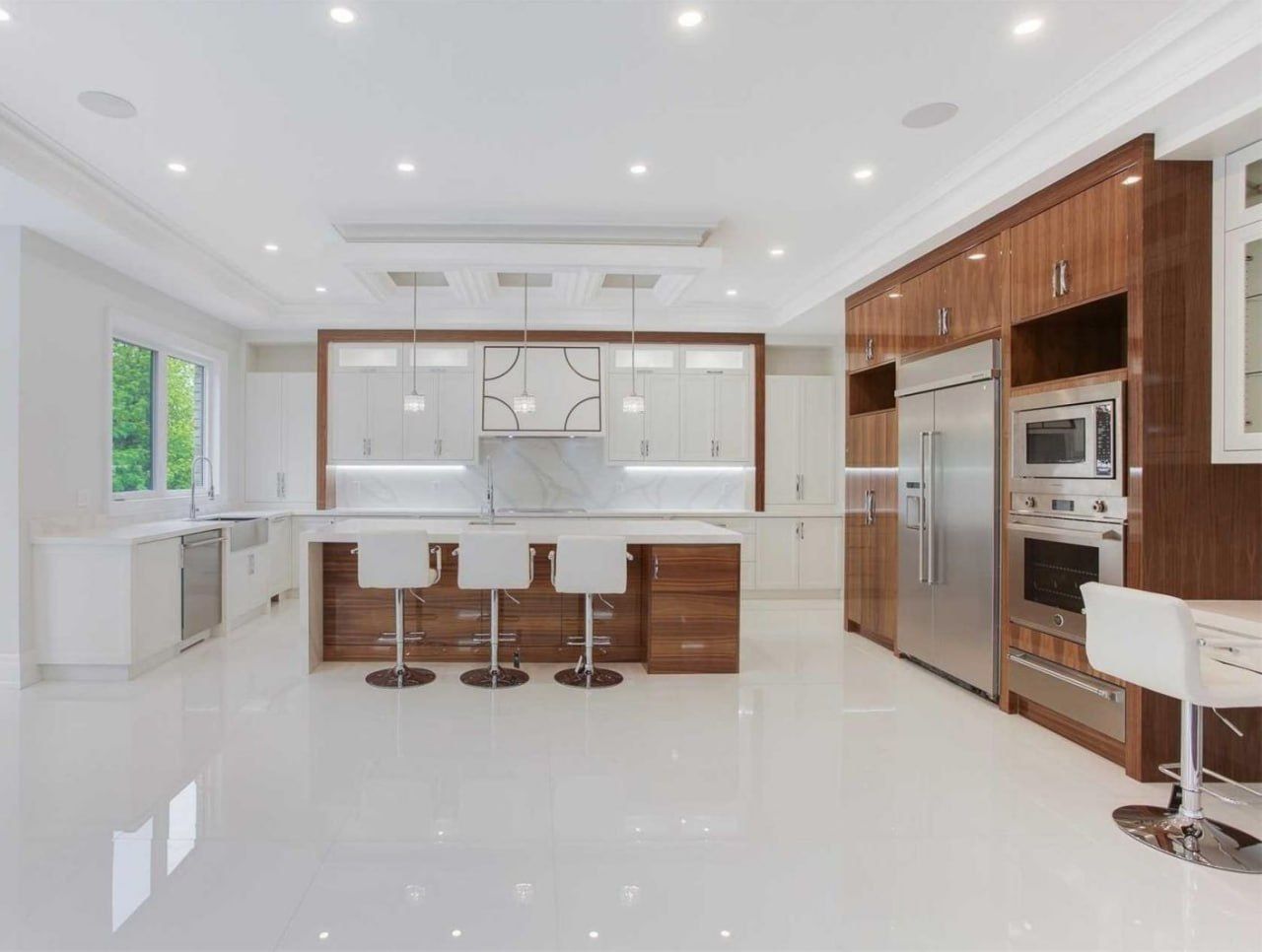 Large white kitchen with walnut accents and high-gloss floor