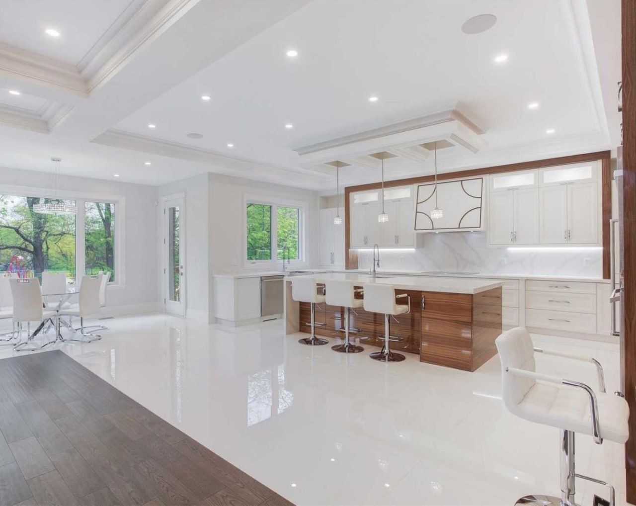 Open-plan white kitchen with island and gloss porcelain floor