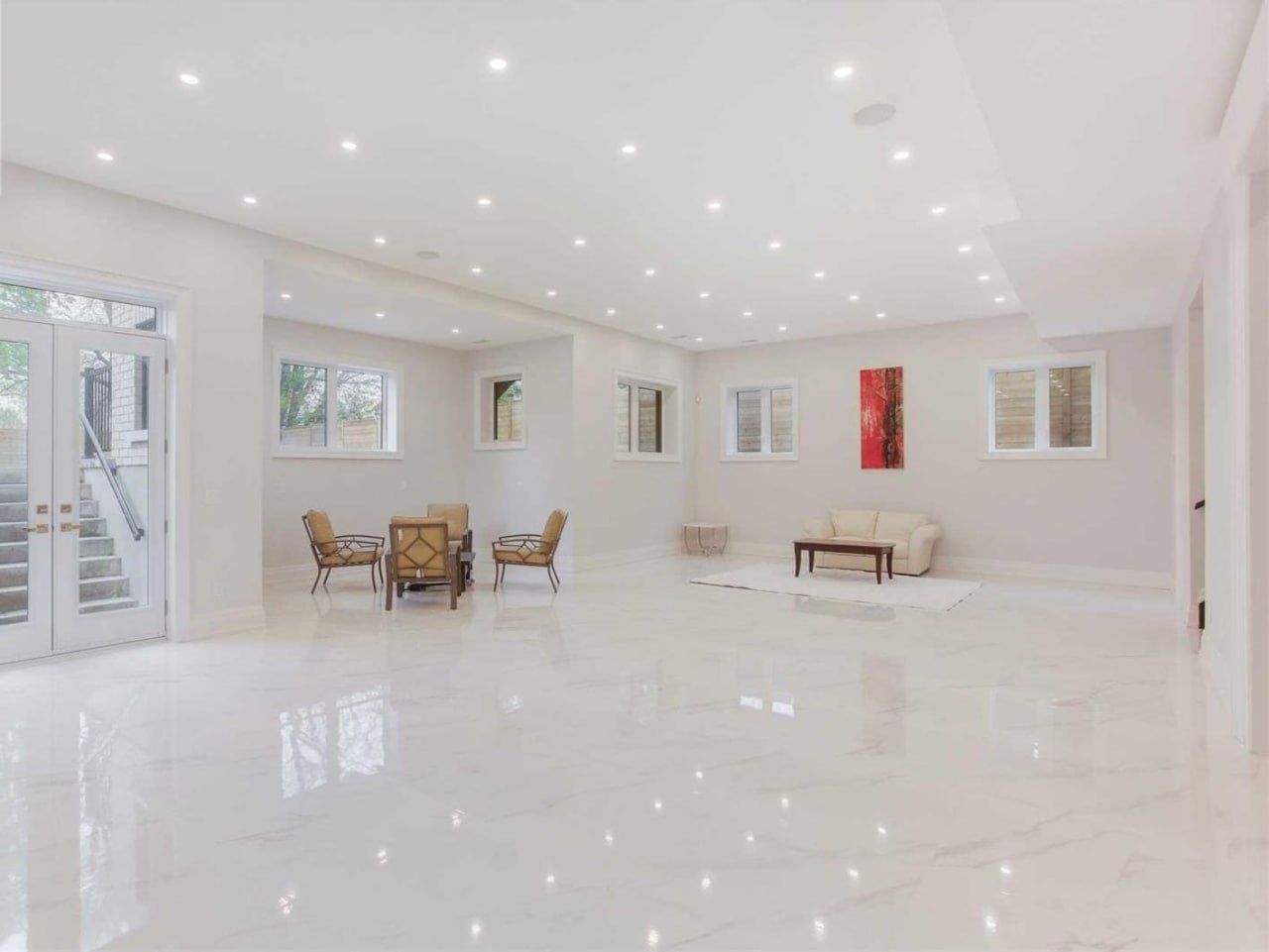Large open living space with polished marble-look porcelain floor