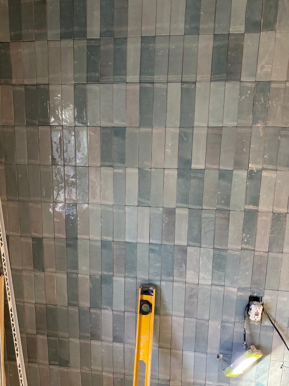 Vertical teal zellige tile wall being levelled