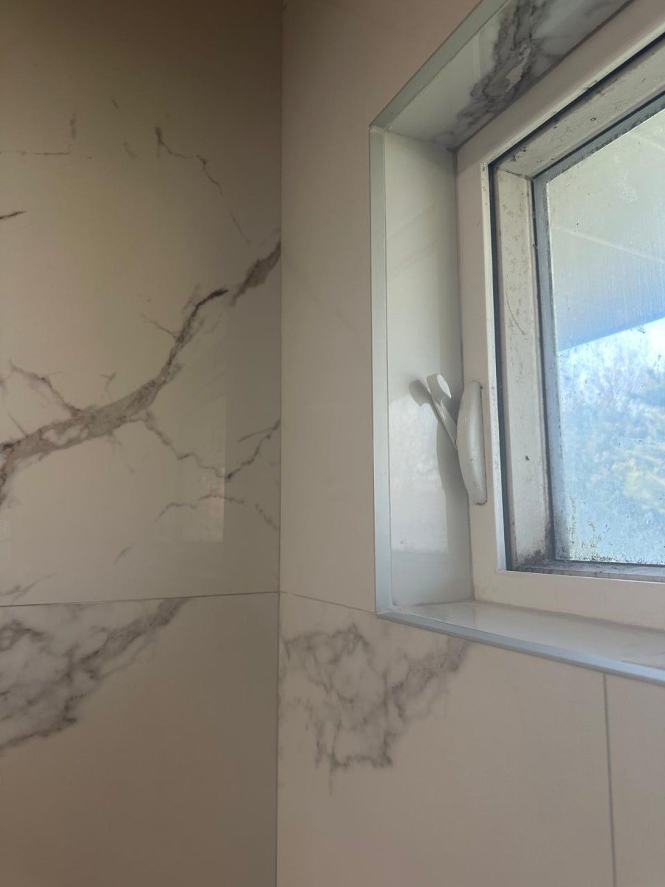 Marble-look tile with mitred window reveal