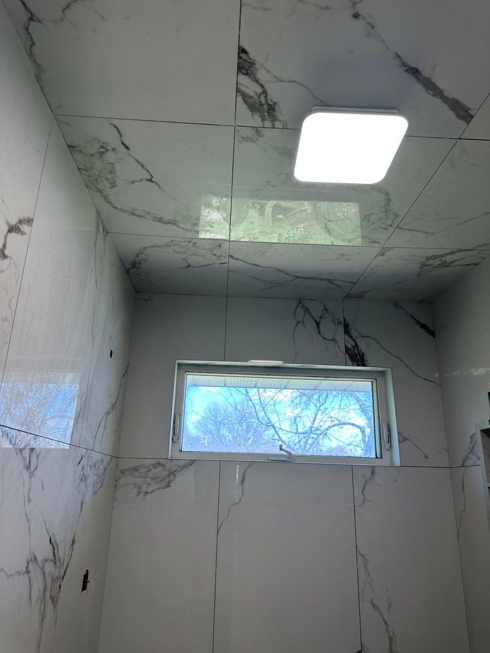 Marble-look porcelain shower with tiled ceiling